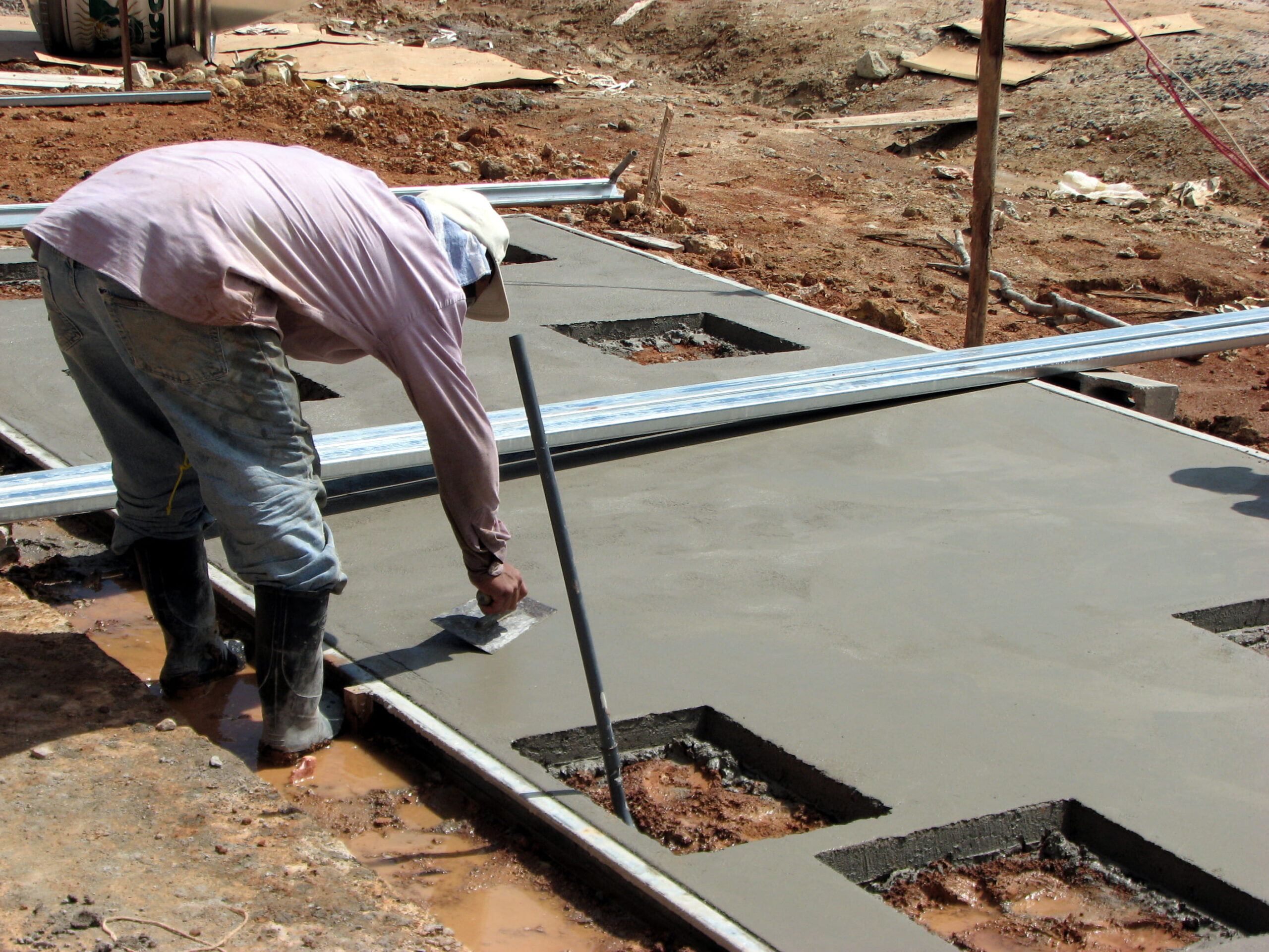 construction worker smoothing wet cement