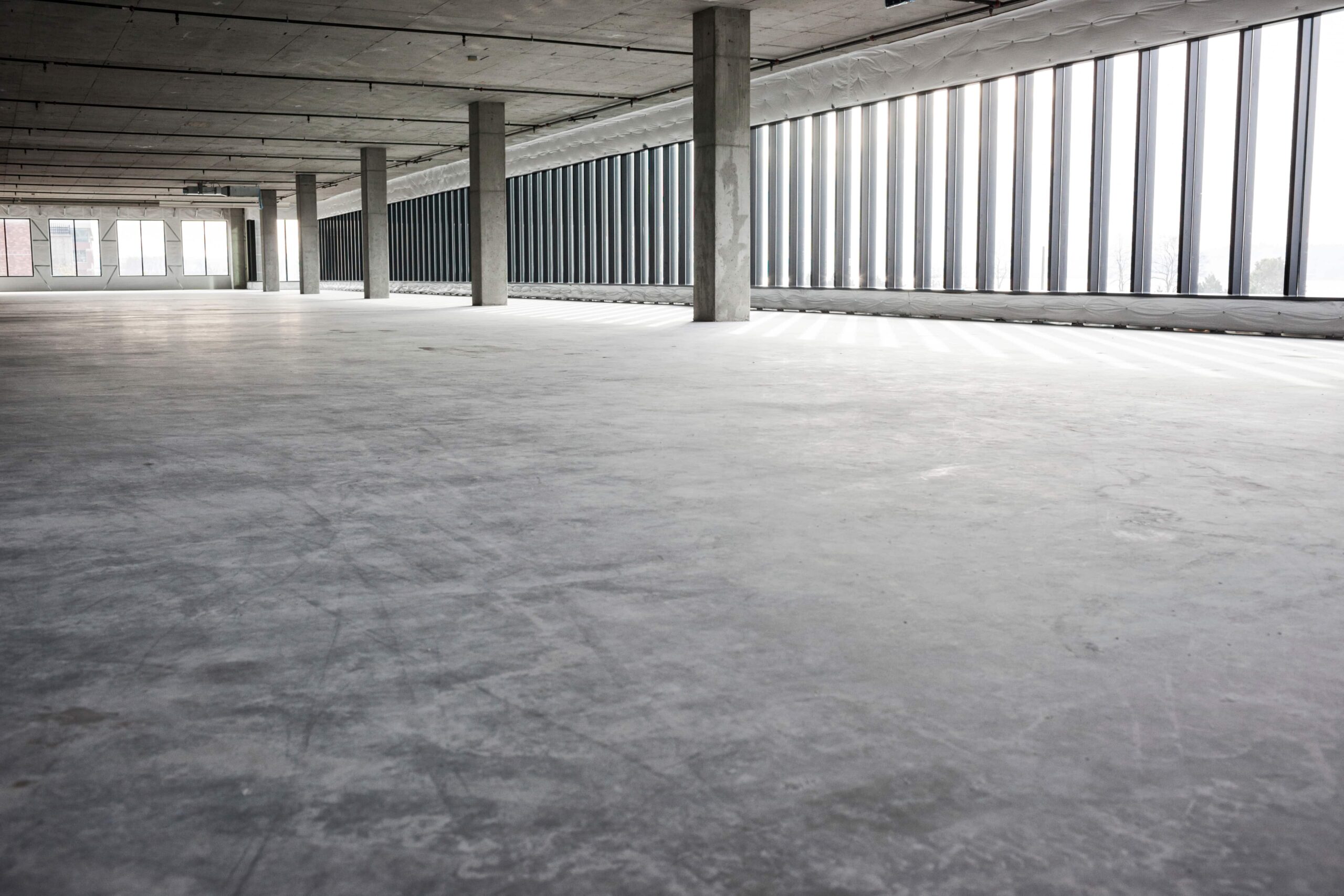empty concrete room with windows and support colum